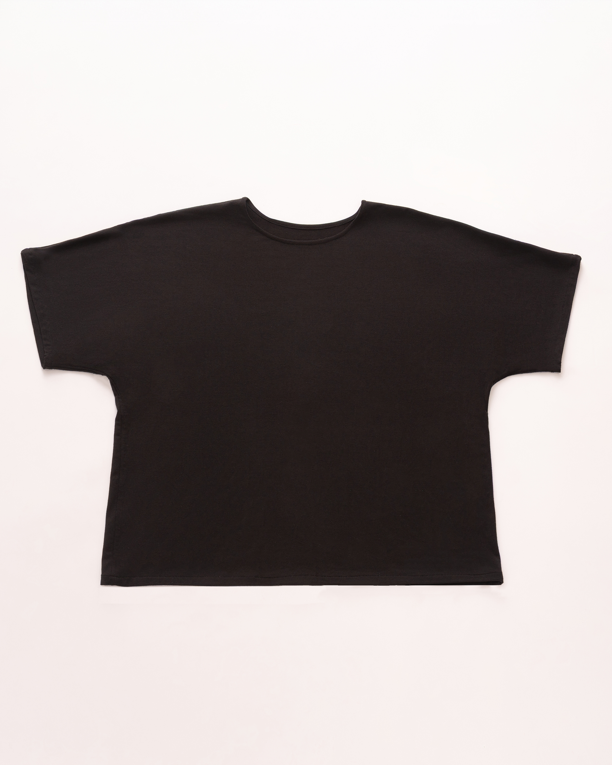 Vestit plana d'una samarreta negra de màniga curta folgada amb una silueta relaxada i gran i mànigues de tall ample, que es mostra sobre un fons clar.